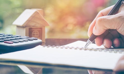 calculating tax while a little house is standing on the table